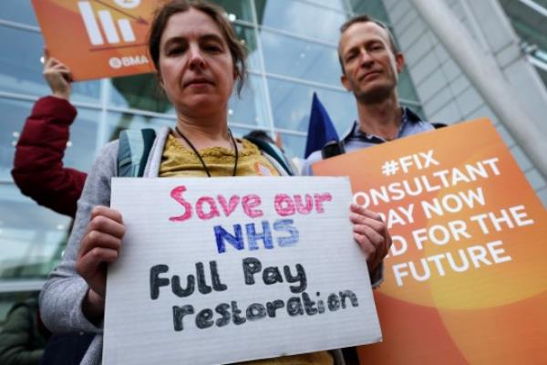 epa10759662 Hospital co<em></em>nsultants hold placards during a picket outside the University College Hospital as their strike co<em></em>ntinues for a second day, in London, Britain, 21 July 2023. Hospital co<em></em>nsultants are striking over pay and work conditions. EPA/ANDY RAIN