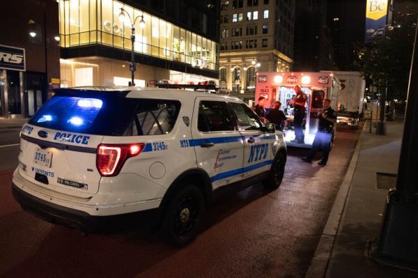 Police officers and EMS are seen treating a man who was stabbed in the head and stomach at 500 5th Ave. in Manhattan.