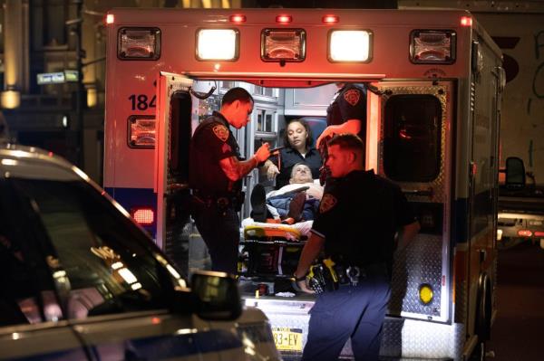 Police officers and EMS are seen treating a man who was stabbed in the head and stomach at 500 5th Ave. in Manhattan.