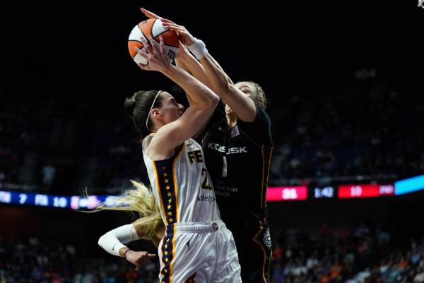 Co<em></em>nnecticut Sun guard Rachel Banham blocking a shot from Indiana Fever guard Caitlin Clark during a WNBA game