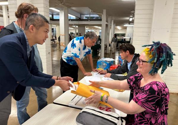 Adrian Tam, the interim chair of the Democratic Party of Hawaii, places his presidential caucus ballot for counting in an envelope on March 6, 2024, in Honolulu.