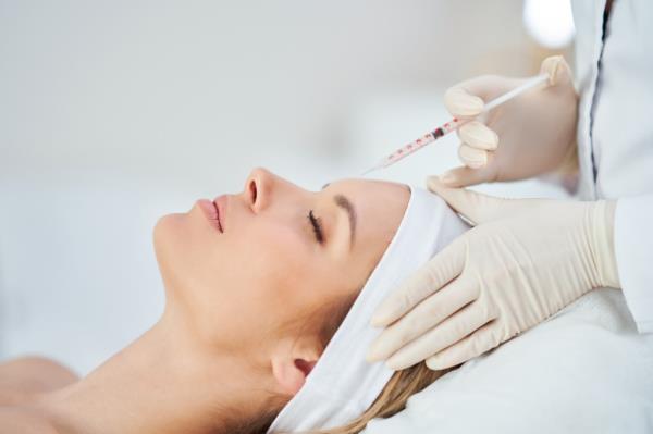 A woman receiving a botox injection during a medical cosmetology treatment