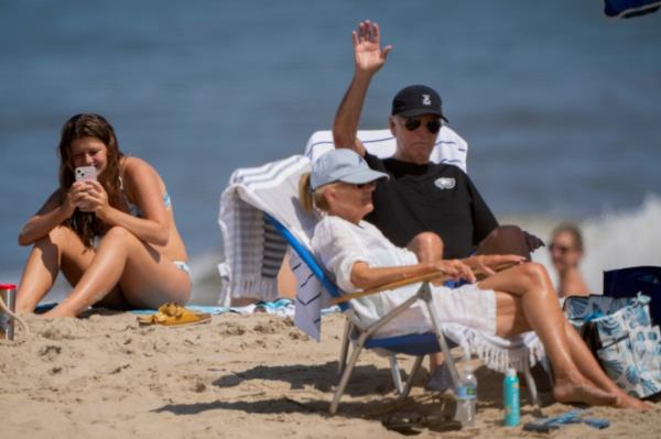 President Joe Biden, with first lady Jill Biden, waves as they sit at the beach in Rehoboth Beach, Del., Saturday, Aug. 31, 2024.