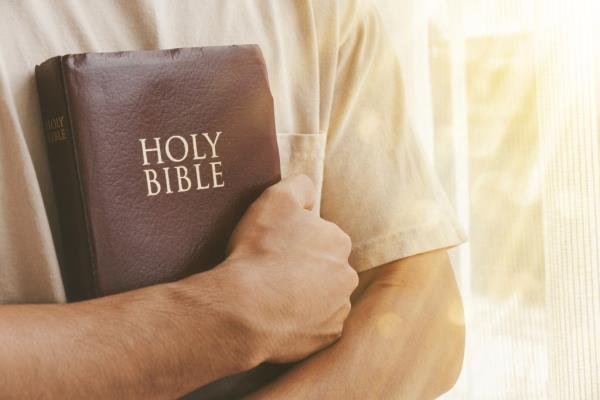 A person's hands holding a bible. 