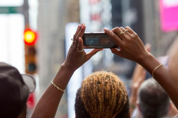 People use their pho<em></em>nes to take pictures of the solar eclipse