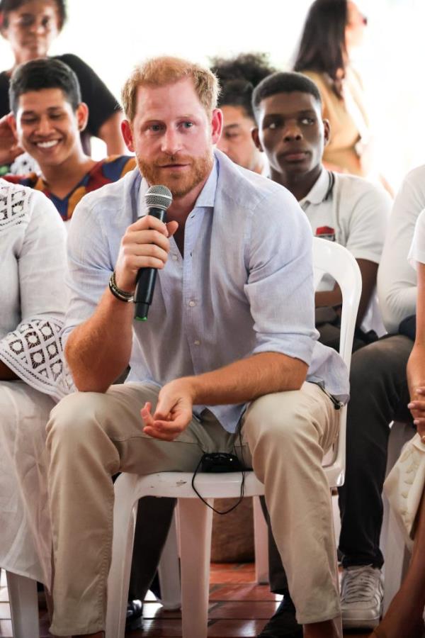 Prince Harry, Duke of Sussex, sitting in a chair holding a microphone during his visit at Unidad Recreativa El Vallado in Cali, Colombia