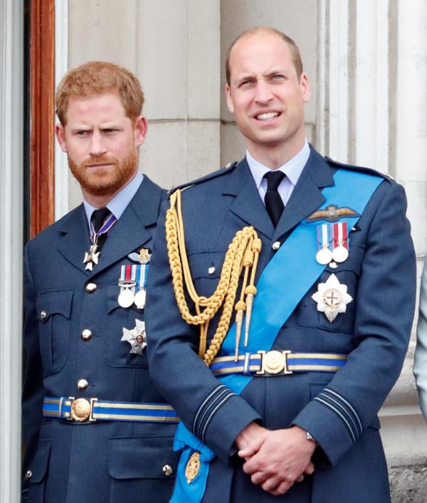 Prince William and Prince Harry in military uniforms, watching a flypast from the balcony of Buckingham Palace to mark the centenary of the Royal Air Force