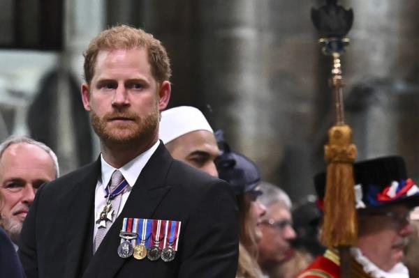 Prince Harry, Duke of Sussex, looking perplexed at King Charles III's departure from Westminster Abbey after coronation