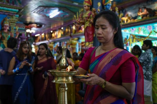 A devotee lights a vilakku or tradition lamp while performing prayers in co<em></em>njunction with Deepavali at the Arulmigu Karumariamman temple in Butterworth. — Bernama pic