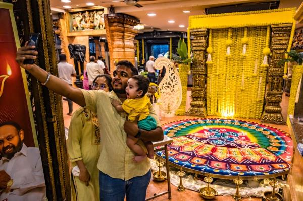 A family takes a selfie with Kolam decorations on the eve of Deepavali at Court Hill Sri Ganesar Temple in Kuala Lumpur November 11, 2023. — Picture by Firdaus Latif