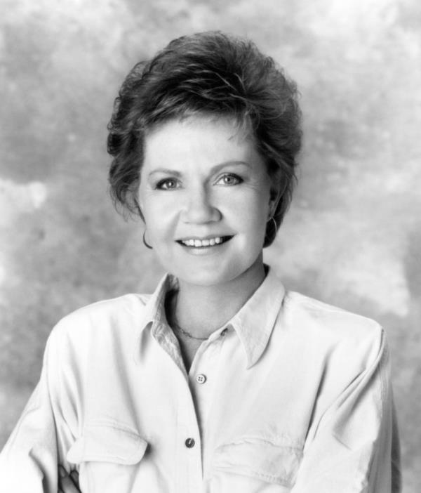 Black and white photo white woman shirt hair smiling.