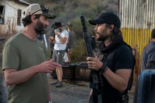 Taylor Kitsch holding a long gun with Jack Carr