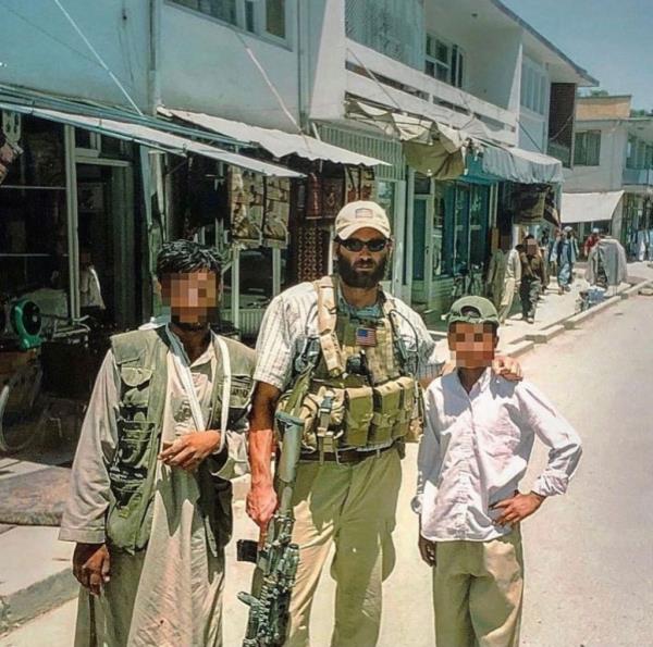 Jack Carr in a street in Afghanistan with his arm on a boy's shoulder