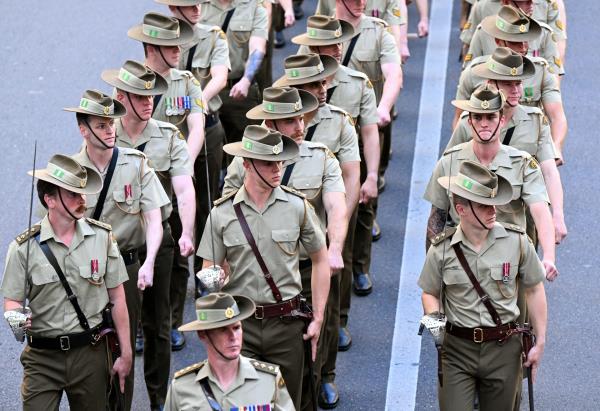 A group of army soldiers in a field walk away