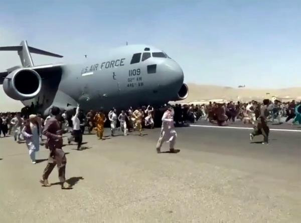 People running next a US Air Force plane in Kabul during the withdrawal from Afghanistan on Aug. 16 2021.