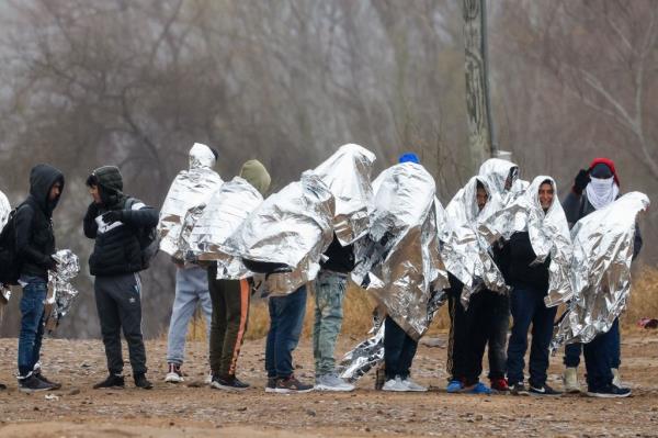 Migrants line up in coats