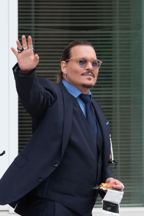 Johnny Depp gestures to fans during a recess outside court 