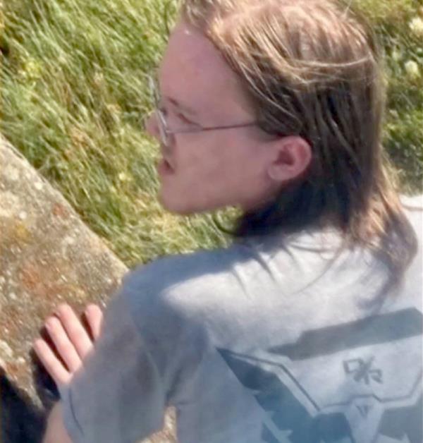 Crooks, 20, seen here on the day of the shooting in a grey t-shirt lying on the ground or roof fired several shots from a rooftop 130 yards away from the rally.