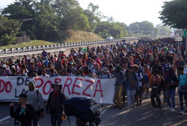 Migrants walk in a caravan heading to the northern border with the US.