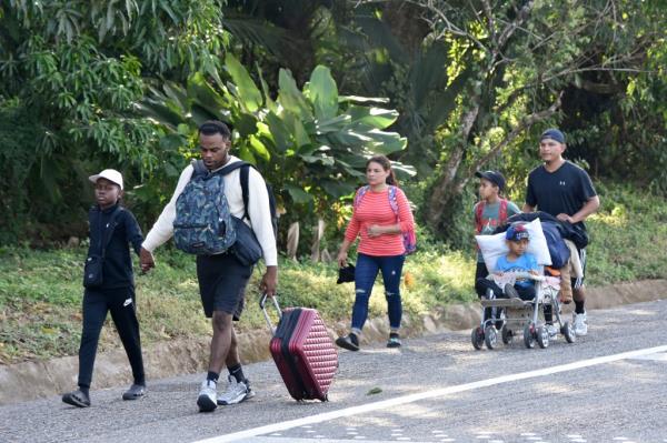 Migrants walk along a highway in Huixtla, Mexico on Monday.