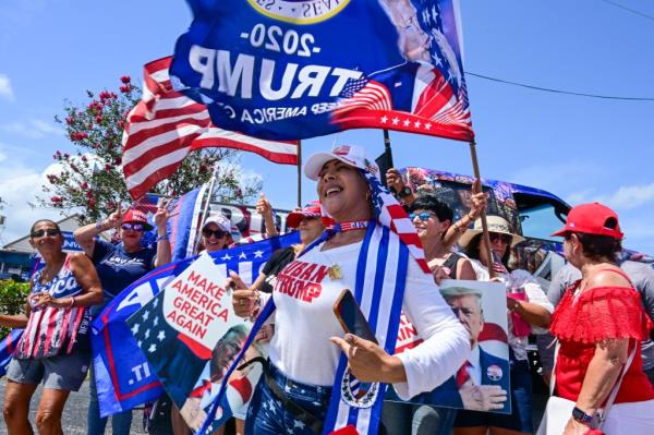 Supporters of former US President Do<em></em>nald Trump hold signs as they show their support for the Republican 2024 presidential candidate during a 