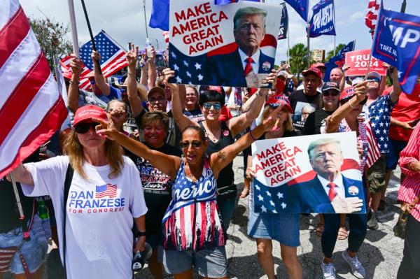 Supporters of former US President Do<em></em>nald Trump hold signs as they show their support for the Republican 2024 presidential candidate during a 