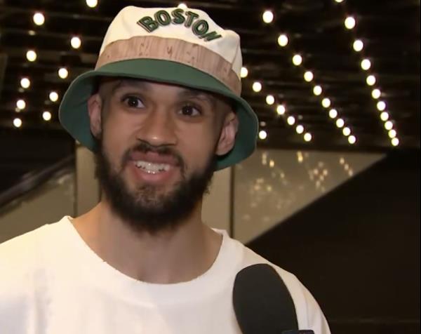 Celtics guard Derrick White shows off his repaired front tooth before the team's champio<em></em>nship parade.