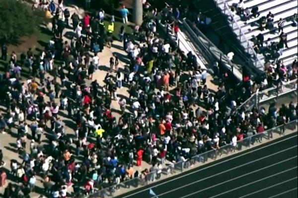 Students and staff gather next to the football field after law enforcement officers respo<em></em>nded to a fatal shooting at Apalachee High School in a still image from aerial video in Winder, Georgia, U.S. September 4, 2024.