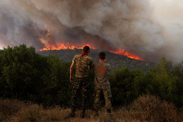 People watching a wildfire burn near the village of Sykorrahi in Greece on August 23, 2023.