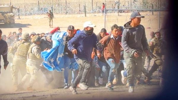 The large crowd of migrants rushed past the Texas Natio<em></em>nal Guard.