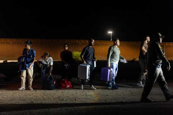 A group of migrants from countries including Bolivia and Brazil are apprehended by Border Patrol agents after crossing into the US in Yuma, Arizona