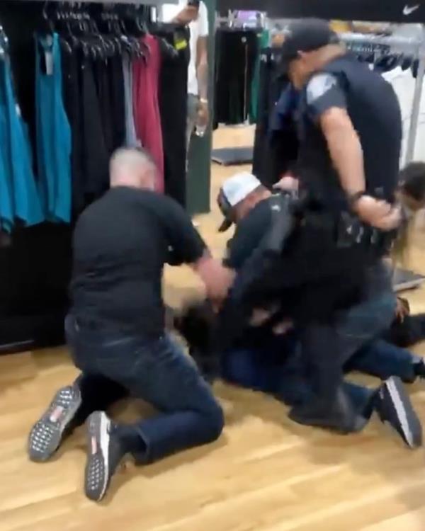 An officer kicks the teen suspect.