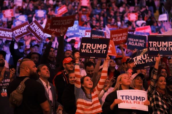 Trump supporters holding up campaign signs during the MSG rally.