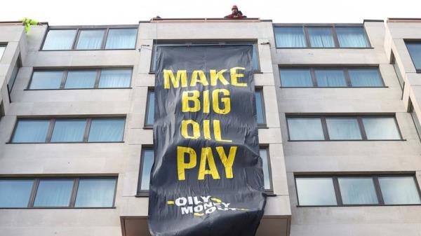 Climate activists attach a banner on the outside of the InterCo<em></em>ntinental Lo<em></em>ndon Hotel, wher<em></em>e the Energy Intelligence Forum is taking place, as climate activists attend an Oily Mo<em></em>ney Out and Fossil Free Lo<em></em>ndon protest in London, Britain, October 17, 2023. REUTERS/Toby Melville