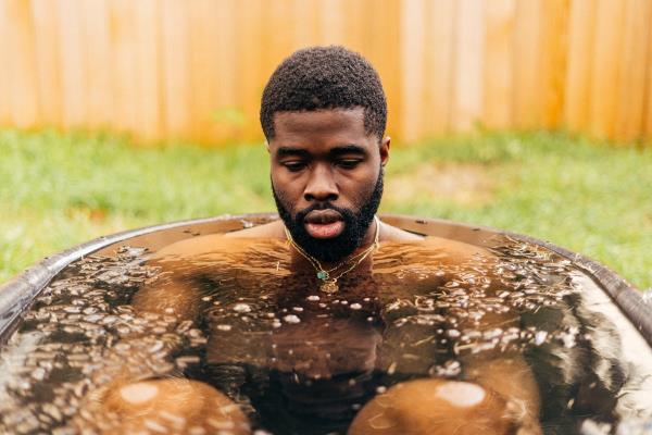 Athletic man doing a cold plunge in his yard