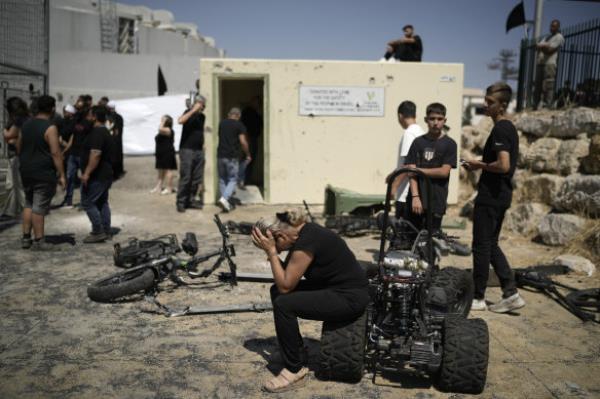 A woman from the Druze minority weeps near the site wher<em></em>e 12 children and teens were killed in a rocket strike on a soccer field.