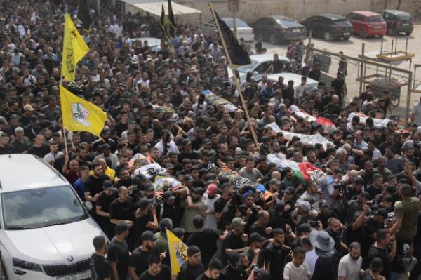 Mourners carry the bodies of Palestinian men killed during an Israeli military operation, some draped in the Palestinian and the Islamic Jihad flags, during their funeral in Jenin, West Bank, also on Friday.