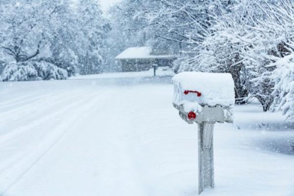 Blinding blizzard snow storm RFD (rural free delivery) roadside mailboxes on a quiet residential district street.