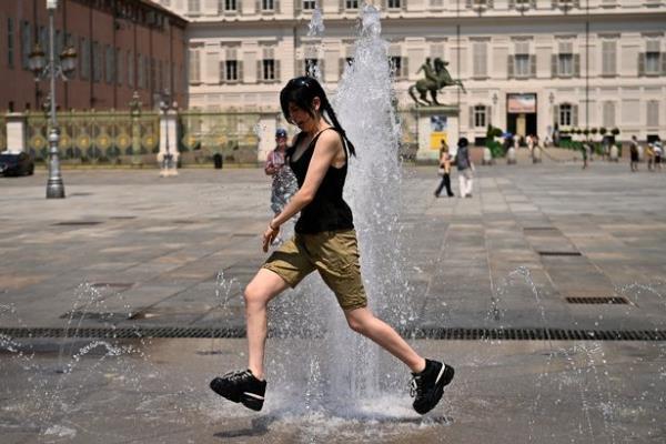 People cooled off in a fountain in Turin yesterday (Tuesday, July 11)