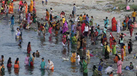 Hindustan Times via Getty Images Women and children bathe in a river during Jivitputrika festival in the Uttar Pradesh state, northern India. Photo: September 2020